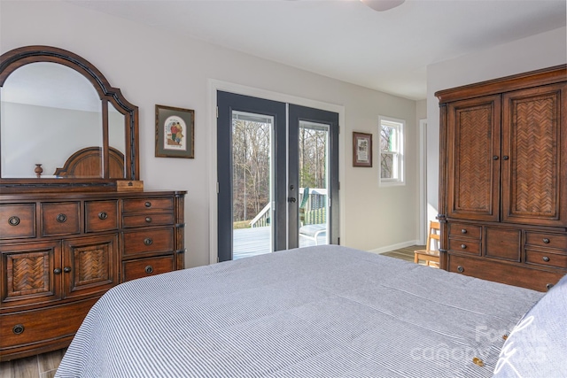 bedroom with french doors, access to exterior, wood finished floors, and baseboards