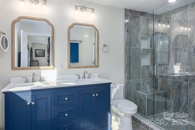 bathroom featuring a sink, toilet, a shower stall, and double vanity