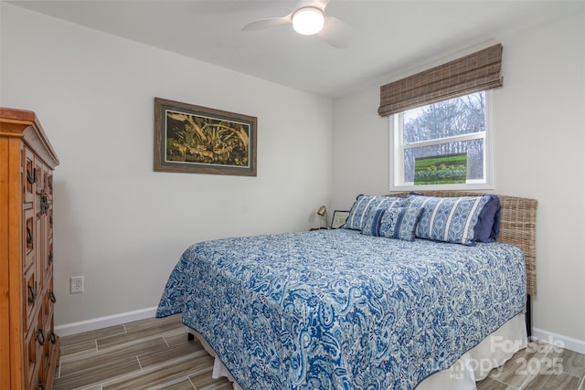 bedroom featuring baseboards, wood tiled floor, and a ceiling fan