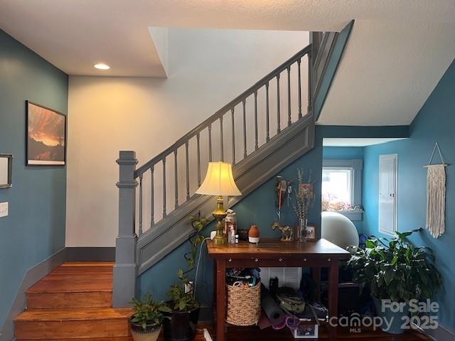 staircase featuring wood finished floors and baseboards