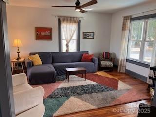 living area with wood finished floors and ceiling fan