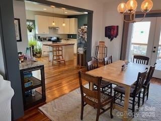 dining space featuring wood finished floors and a chandelier