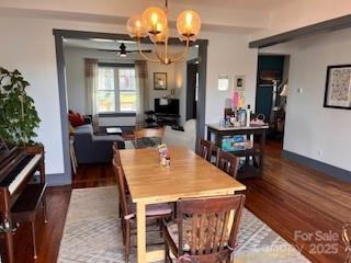 dining room with wood finished floors and ceiling fan with notable chandelier