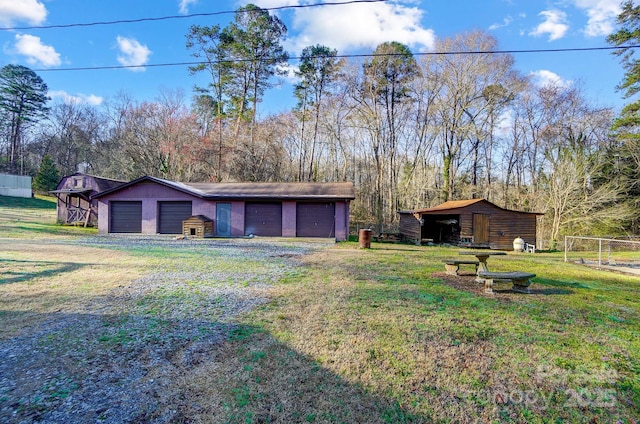 view of yard with an outbuilding, fence, and a detached garage