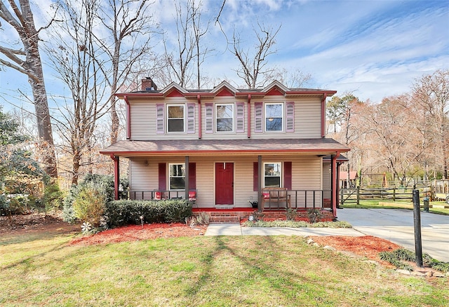 view of front of house featuring a front lawn, covered porch, a chimney, and fence