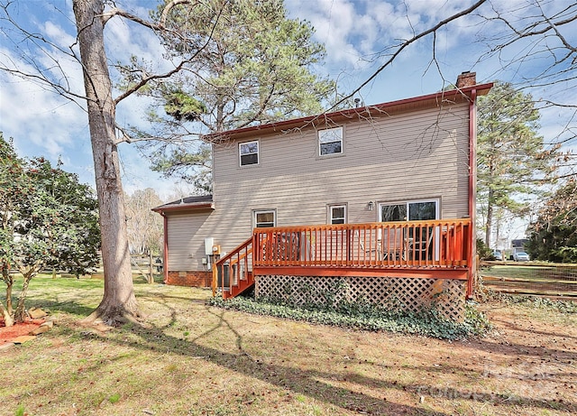 back of property with crawl space, a yard, a deck, and a chimney