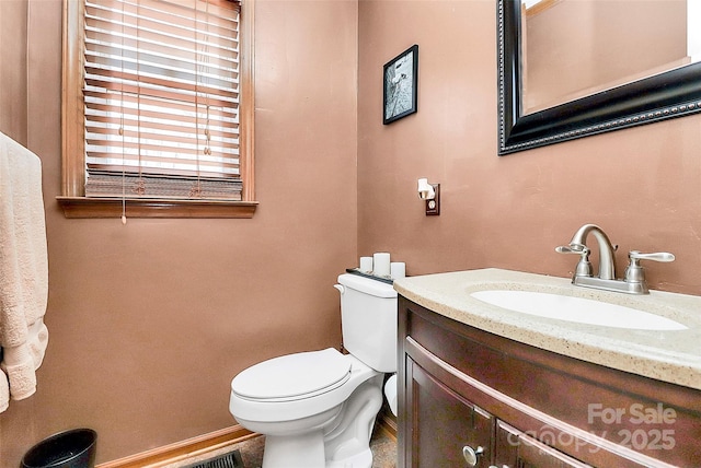 bathroom with vanity, toilet, and baseboards