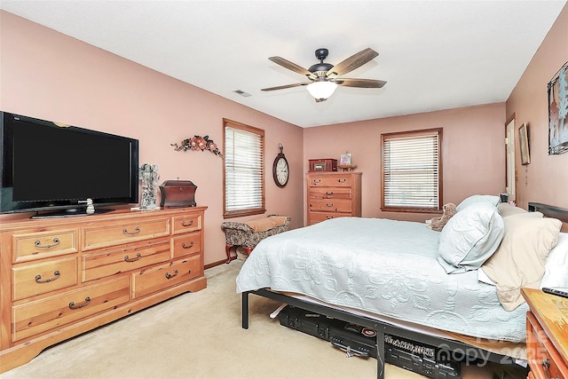 bedroom featuring visible vents, light carpet, and a ceiling fan