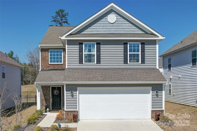 traditional home with driveway, fence, roof with shingles, a garage, and brick siding