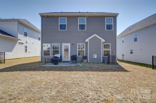 rear view of house featuring a yard, central air condition unit, and a patio