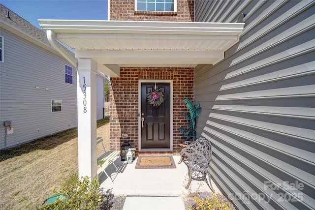 view of exterior entry featuring brick siding