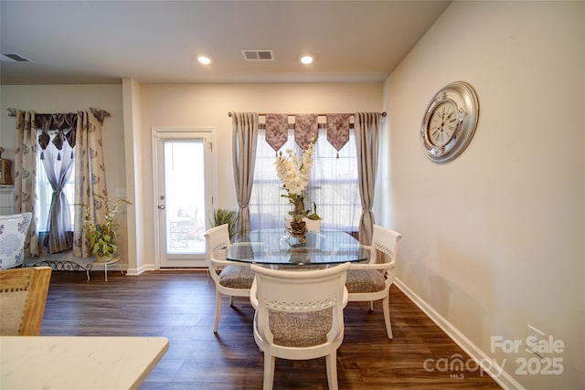 dining space with dark wood finished floors, visible vents, and baseboards