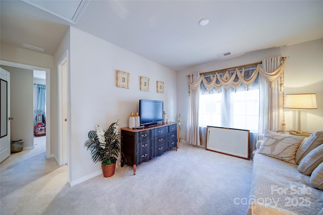 living area with visible vents, light carpet, and baseboards