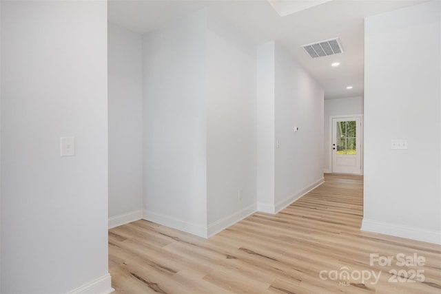 corridor featuring light wood-style floors, baseboards, visible vents, and recessed lighting