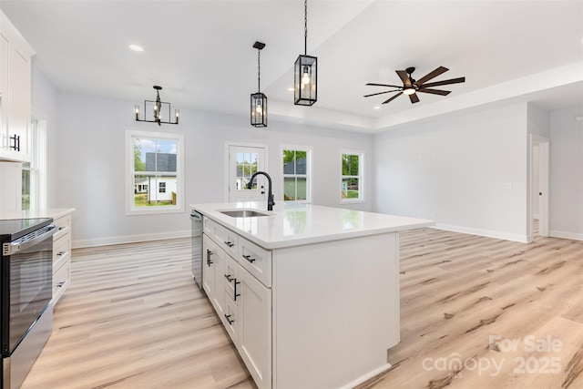 kitchen featuring light wood-style floors, stainless steel dishwasher, light countertops, a sink, and electric stove