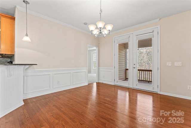 3104 Streamhaven Dr, Indian Land, SC 29707 - unfurnished dining area featuring crown molding, a notable chandelier, wood finished floors, and wainscoting
