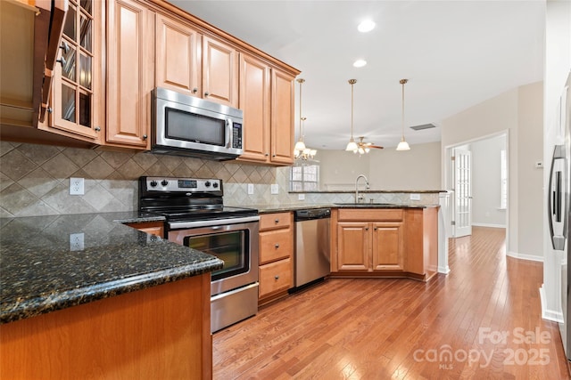 3104 Streamhaven Dr, Indian Land, SC 29707 - kitchen with backsplash, appliances with stainless steel finishes, a peninsula, light wood-style floors, and a sink