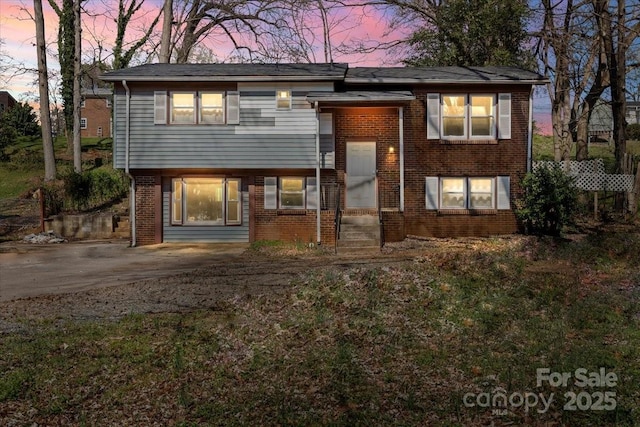 raised ranch featuring brick siding