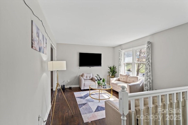 living area with baseboards and wood finished floors