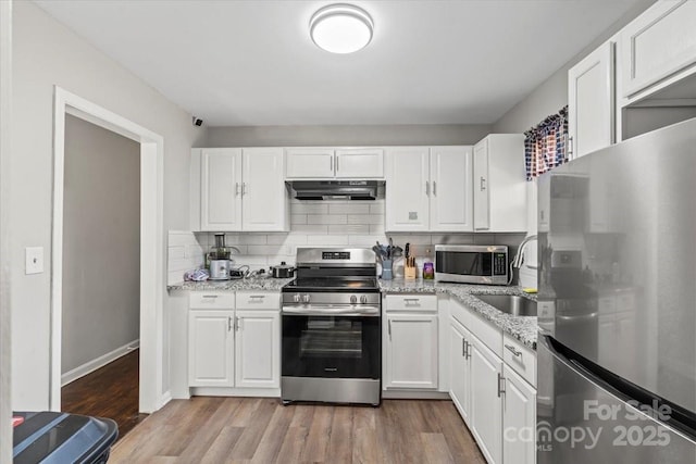 kitchen featuring under cabinet range hood, appliances with stainless steel finishes, and white cabinetry