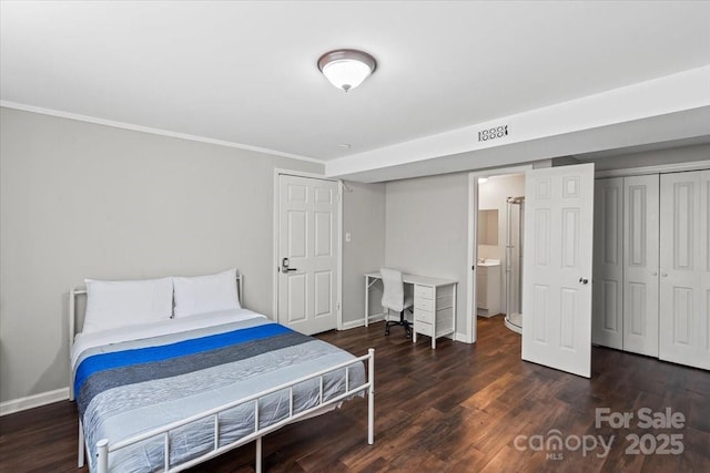 bedroom featuring a closet, baseboards, wood finished floors, and crown molding