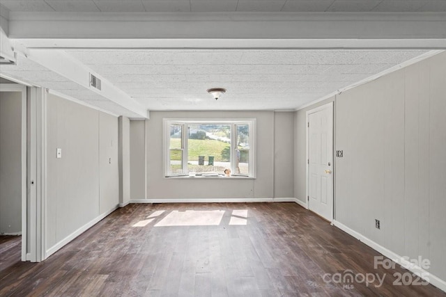 spare room with visible vents, baseboards, and wood finished floors