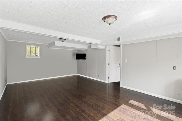 empty room with visible vents, baseboards, and wood-type flooring