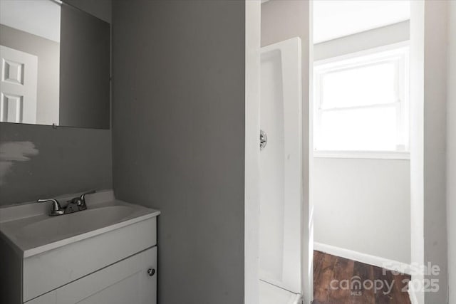 bathroom with vanity, baseboards, and wood finished floors