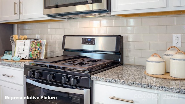 kitchen featuring light stone counters, tasteful backsplash, stainless steel range with gas cooktop, and white cabinets