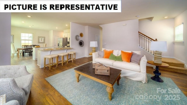 living room featuring stairway, recessed lighting, wood finished floors, and baseboards