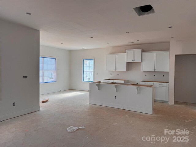 713 Inwood Hill Dr Unit 96, Gastonia, NC 28056 - kitchen with a kitchen island, white cabinetry, and baseboards