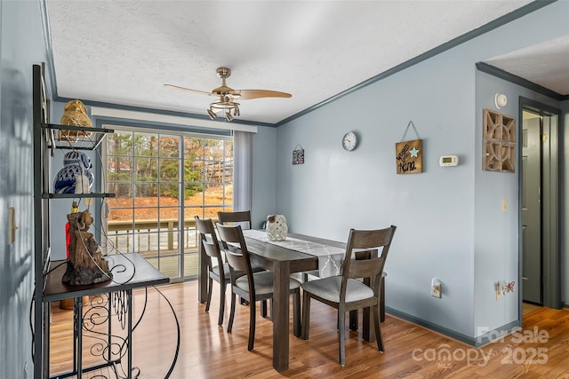 dining room with baseboards, wood finished floors, a ceiling fan, and ornamental molding