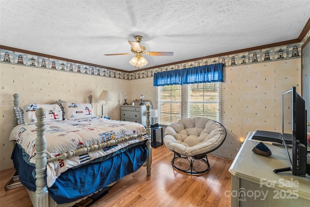 bedroom with ornamental molding, a textured ceiling, and wood finished floors