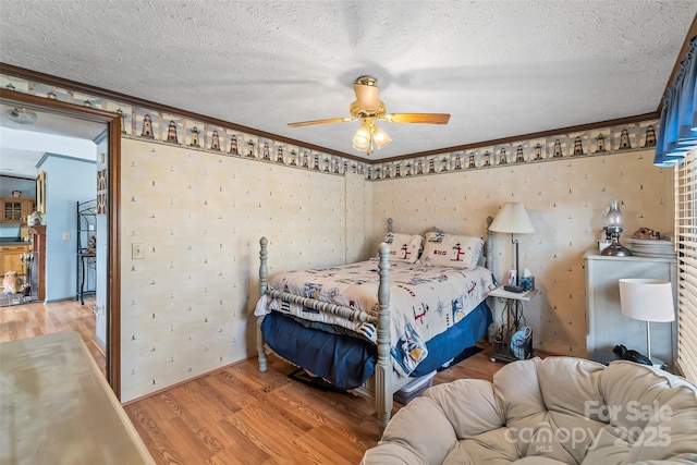 bedroom with a textured ceiling, light wood-style floors, and ornamental molding