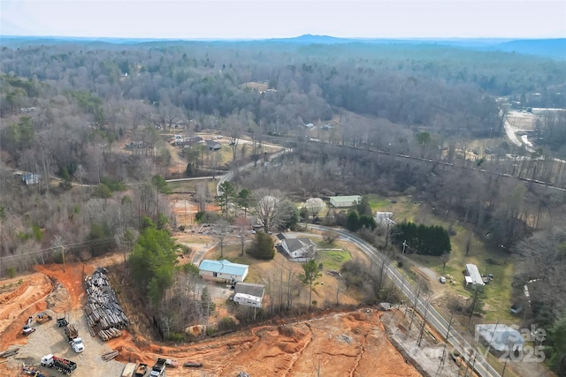 bird's eye view with a wooded view