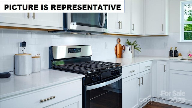 kitchen featuring stainless steel appliances, backsplash, light countertops, and white cabinetry