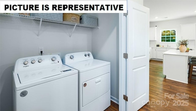 laundry area featuring a sink, laundry area, dark wood-style flooring, and washer and clothes dryer