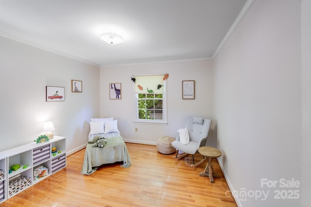 living area with baseboards, ornamental molding, and wood finished floors
