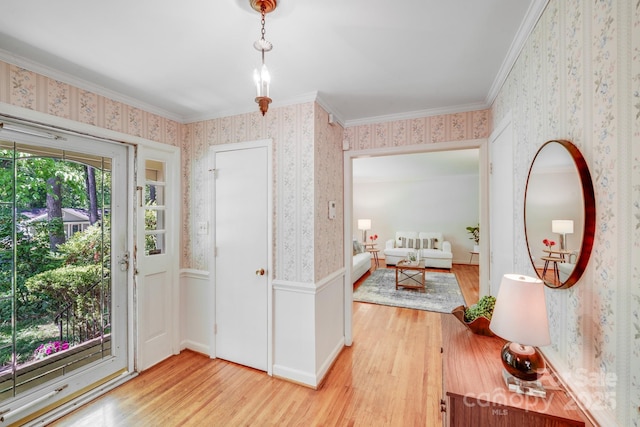 entryway featuring ornamental molding, wood finished floors, and wallpapered walls