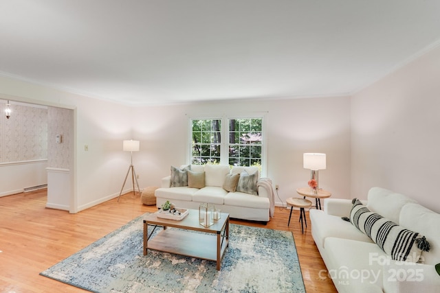 living area with baseboards, ornamental molding, and wood finished floors