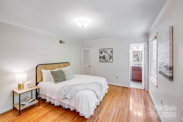 bedroom featuring visible vents, ornamental molding, light wood-style floors, baseboards, and connected bathroom