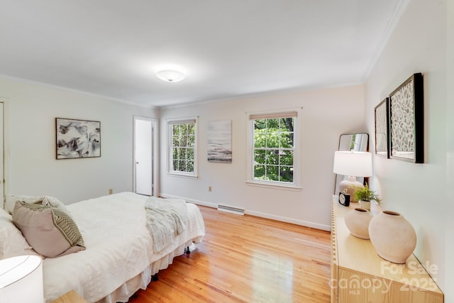 bedroom featuring crown molding, baseboards, wood finished floors, and visible vents