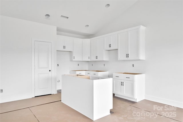 8455 W NC-152 Hwy, Mooresville, NC 28115 - kitchen with a kitchen island, white cabinetry, and vaulted ceiling