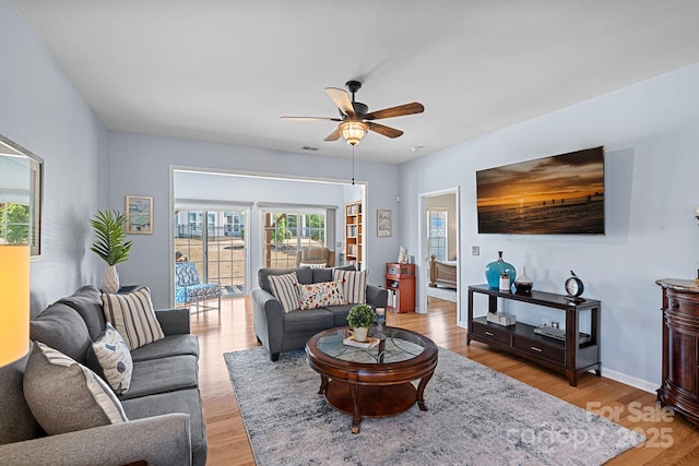 living area featuring light wood finished floors and ceiling fan
