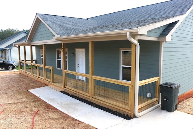 view of home's exterior with covered porch and roof with shingles