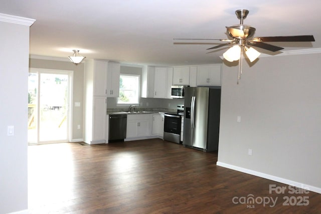 kitchen with baseboards, ceiling fan, stainless steel appliances, dark wood-type flooring, and white cabinetry