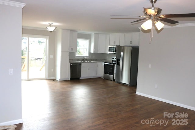 kitchen featuring dark wood-style floors, white cabinets, appliances with stainless steel finishes, and a sink