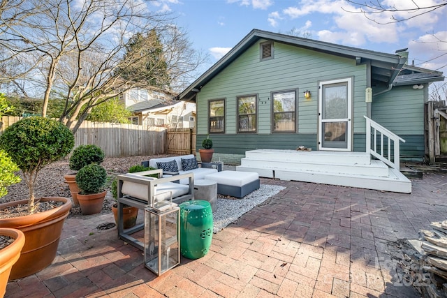 rear view of house with fence, an outdoor living space, and a patio area