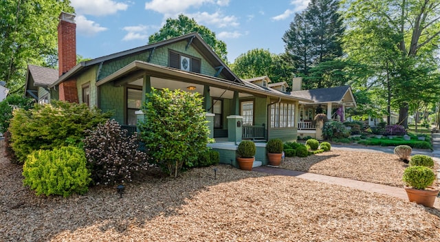 view of front of property with a chimney and a porch