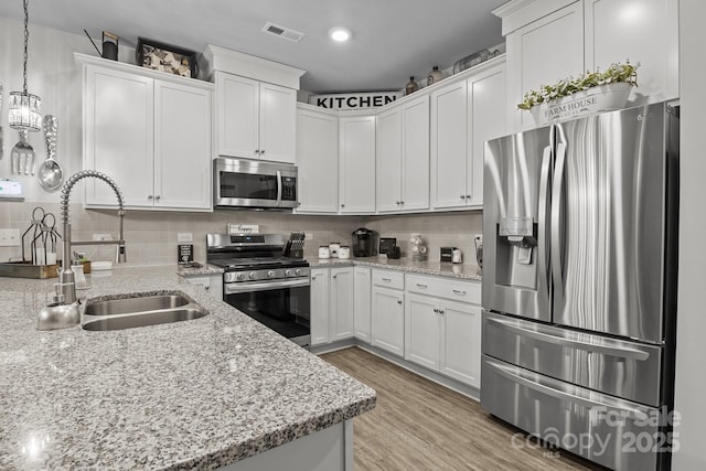 7172 Indigo Way, Denver, NC 28037 - kitchen featuring appliances with stainless steel finishes, a sink, white cabinetry, decorative backsplash, and recessed lighting